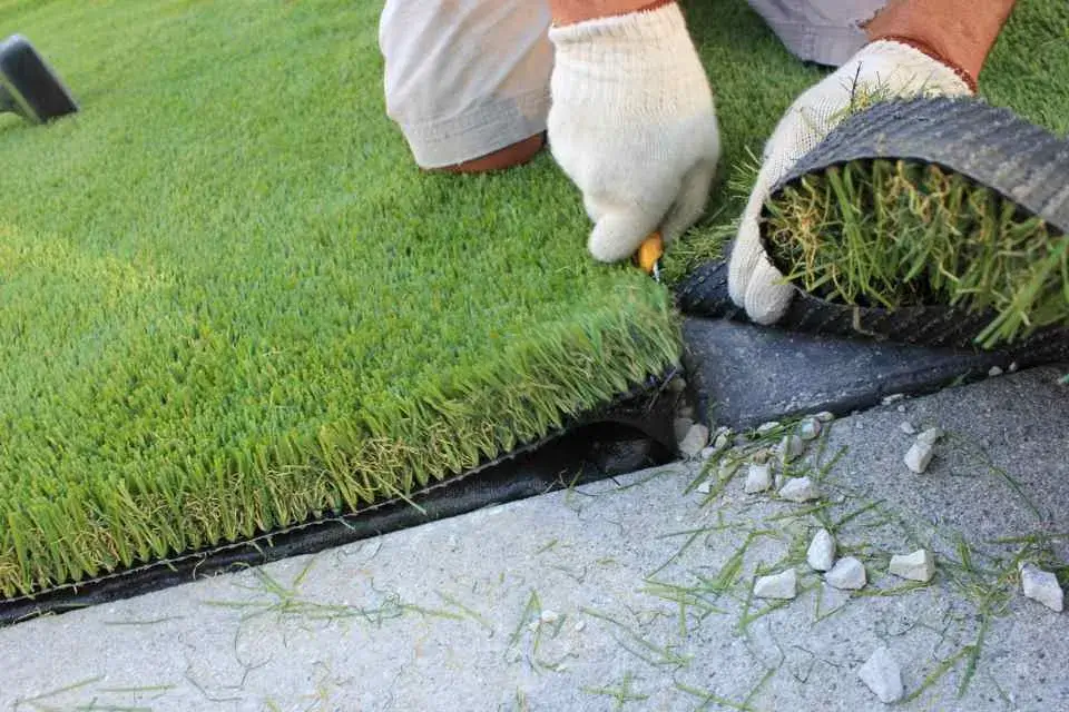 Installer cutting turf along a hard edge